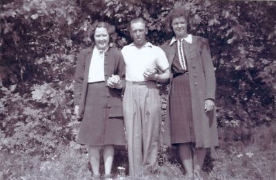 2 kvinnor och 1 man stående i naturen
