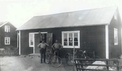 2 män med cyklar stående framför byggnad
Nyckelord: Cykel