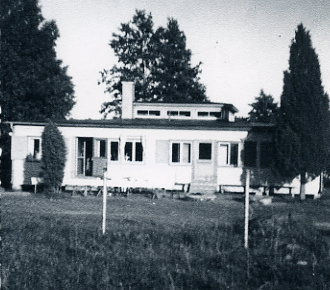 En fyrkantig platt byggnad med många fönster
Nyckelord: Hus Staket