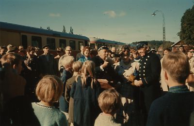 En mängd människor samlade runt 2 uniformsklädda män
Nyckelord: Folksamling Tågstation Dräkt