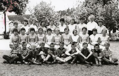 Kvinna och ett antal barn sittande och stående utomhus
Nyckelord: Skolklass, Elever, Klassfotografi 