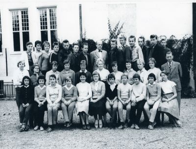 Man och ungdomar sittande och stående utanför skolbyggnad
Nyckelord: Elever, Skolklass, Realskola, Klassfoto