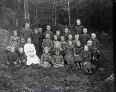 Kvinna med grupp barn i skogsbacke
Nyckelord: Skola