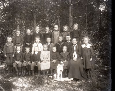 Kvinna med en grupp barn och en hund
Nyckelord: Hund Dräkt Skola