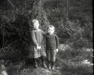 Flicka och pojke stående i skogen
Nyckelord: Dräkt