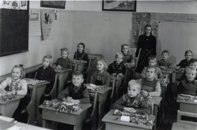 Skolbarn sittande i bänkar med lärarinna i bakgrunden
Nyckelord: Skolsal Elever Klassrum Skolklass Skolfoto Skolfotografi Klassfoto Klassfotografi