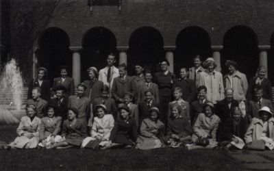 Män och kvinnor och ungdomar stående och sittande framför byggnad
Nyckelord: Elever Skolresa