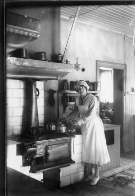 Kvinna stående vid spisel.
Nyckelord: Kök