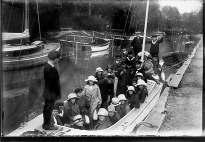 Ett antal sittande och stående personer i båt.
Nyckelord: Utflykt Hatt