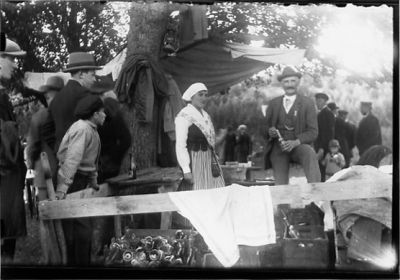 Ett antal personer stående i en park.
Nyckelord: Dräkt Fest Klockkedja