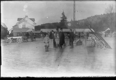 Ett antal personer stående på torg.
Nyckelord: Handel