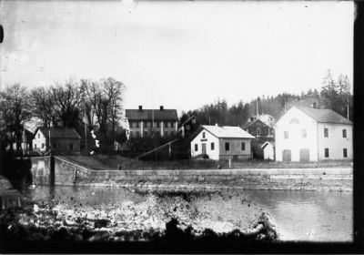 Vattendrag med byggnader i bakgrunden.
