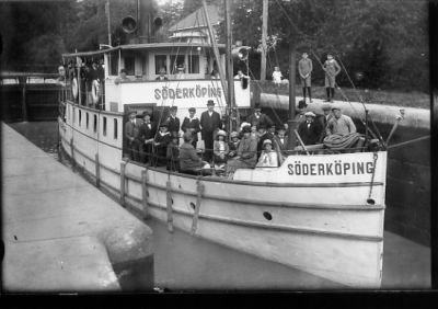 Ett antal personer på båt i sluss.
Nyckelord: Göta Kanal