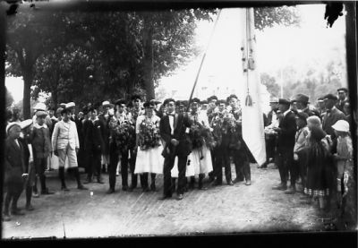 Ett antal personer stående med flagga i park.
Nyckelord: Skolavslutning Folksamling Dräkt