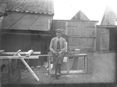 Man sittande på gård.
Nyckelord: Gård