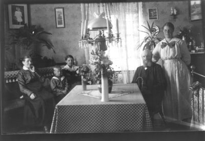 Familj i finrum.
Nyckelord: Taklampa