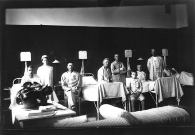 Ett antal personer vid och i sjuksängar.
Nyckelord: Sjuksängar