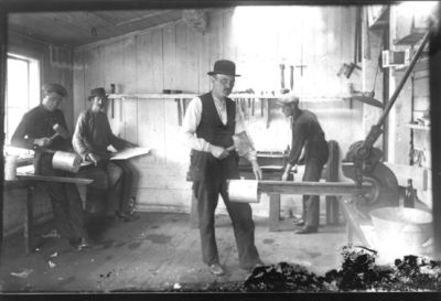 4 män arbetande med plåt.
Nyckelord: Arbetsbänk Verktyg