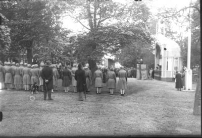 Ett antal personer stående i park.
Nyckelord: Högtidlighet