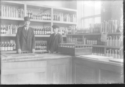 2 män stående bakom disken i affär.
Nyckelord: Butik Spritflaskor