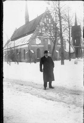 Man stående framför kyrka.
Nyckelord: Klockstapel Vinter