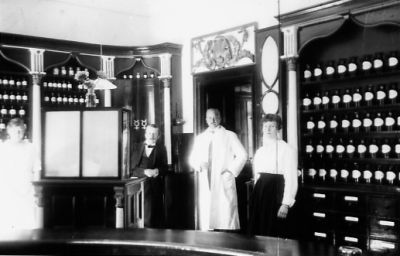 2 män och 2 kvinnor bakom disken i ett apotek.
Nyckelord: Medicinburkar