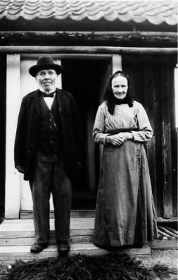 1 man och 1 kvinna stående framför bostad.

