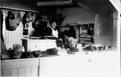 Kvinna stående bakom disk i affär.
Nyckelord: Expedit Kött