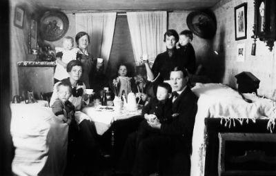 Familj sittande i finrum.
