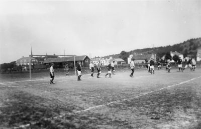 Ett antal män spelande fotboll.
Nyckelord: Fotbollsmatch