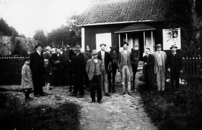 Ett antal personer stående framför byggnad.
Nyckelord: Häst