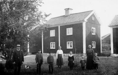 Familj stående framför byggnad.
Nyckelord: Bostad
