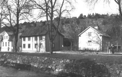 Byggnad bakom vattendrag.
