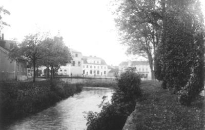 Vattendrag med byggnader i bakgrunden.
