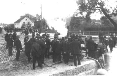 Ett antal personer samlade kring brandspruta.
Nyckelord: Brandspruta