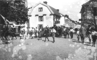 Ett antal personer gående på torg.
Nyckelord: Flagga Kullersten