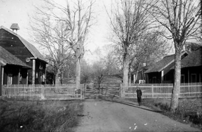 Flicka stående framför tomt med byggnad.
Nyckelord: Lantgård