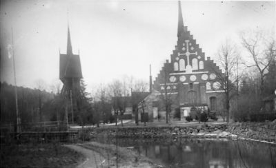 Kyrka bakom vattendrag.
Nyckelord: Klockstapel Storån