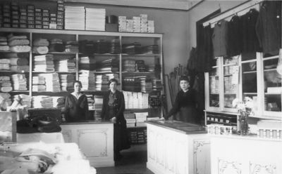 3 kvinnor stående bakom disken i affär.
Nyckelord: Affärsinredning