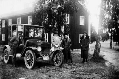 Man och 3 kvinnor stående vid bil.
Nyckelord: Bil