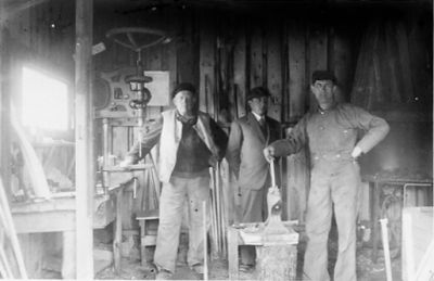 3 män stående i smedja.
Nyckelord: Smedja