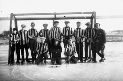 12 stående män framför bandymål.
Nyckelord: Idrottslag Vinter