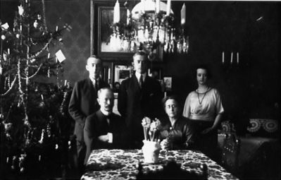 5 personer stående och sittande i finrum.
