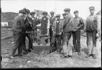 10 män stående vid städ.
Nyckelord: Städ