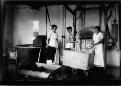 3 kvinnor stående i tvättstuga.
Nyckelord: Tvättstuga