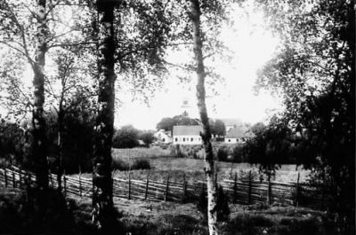 Landskapsvy med byggnad i bakgrunden.
Nyckelord: Gärdesgård