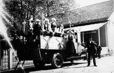 Ett antal personer stående på och bredvid lastbil.
Nyckelord: Lastbil