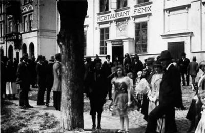 Ett antal personer framför byggnad.
Nyckelord: Skylt Dräkt