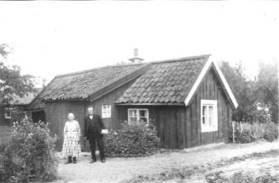 Man och kvinna stående framför byggnad.
Nyckelord: Trädgård Byggnadsstil