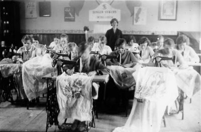 Kvinnor sittande vid symaskiner.
